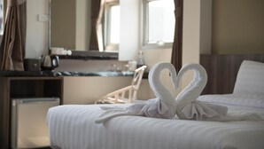 A hotel room with a neatly made bed, a desk with a coffee maker, and a mirror. - Veethara Boutique Hotel (Udon Thani)