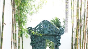 A pathway leading to a decorative metal gate surrounded by bamboo. - Harmony Villas Lombok (Kuta)