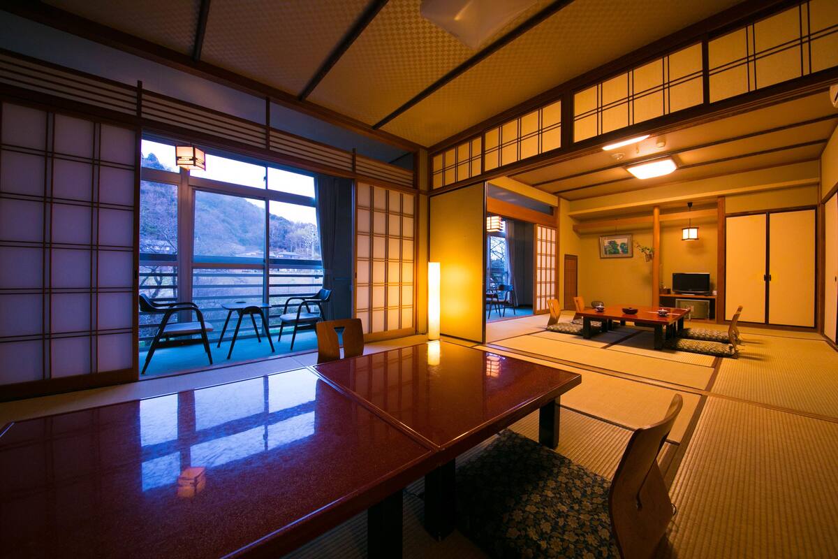 A traditional Japanese room with tatami flooring, a low table, and sliding doors.
