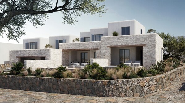 A modern building with a stone facade, multiple balconies, and outdoor seating areas. - Anastasia Resort by Spilia (Mykonos)