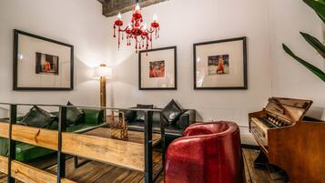 A modern living room with a green sofa, a red chair, a wooden coffee table, and a piano.
