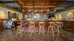 A bar area with wooden bar stools, a counter with bottles, and a chalkboard menu. - Chengdu Sonderia Hostel&Bar-Lazybones (Chengdu)