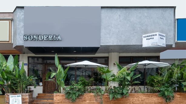 A modern building with the name 'Sonderia' prominently displayed. There are outdoor seating areas with umbrellas and potted plants. - Chengdu Sonderia Hostel&Bar-Lazybones (Chengdu)