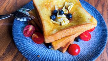 A plate with toast, blueberries, and cherry tomatoes.