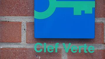 A sign with a key symbol and the text "Clef Verte 2021" on a brick wall.