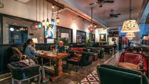 Un intérieur chaleureux avec des meubles en bois, des luminaires suspendus et un tapis à motifs.