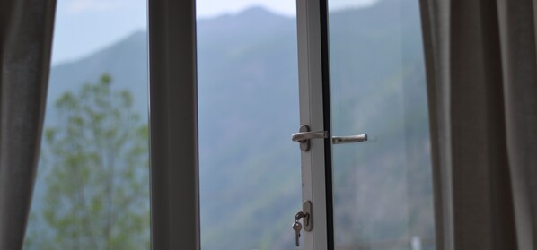 A window with a view of mountains and trees.