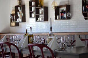 Comedor con una mesa lista para cuatro, copas y botellas de vino.