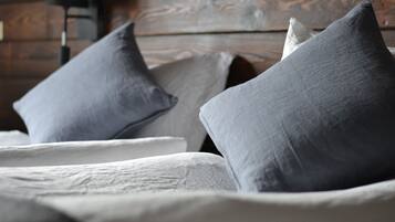 A bed with grey pillows and a white comforter.