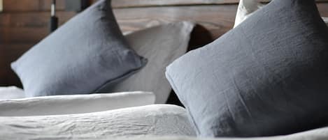 A bed with grey pillows and a white comforter.