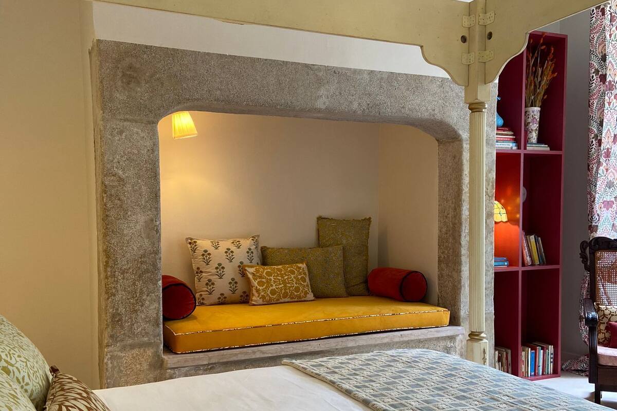 A cozy room with a built-in bench, a bookshelf, and a patterned rug.