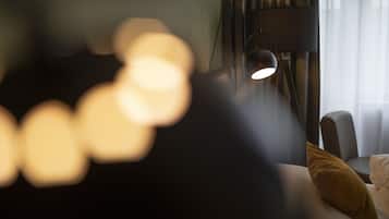 Una vista borrosa de una cama con almohada, una lámpara y una ventana con cortinas.