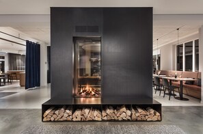 A modern interior with a central fireplace, a dining area, and a seating area. - Domizil Tuebingen (Tuebingen)