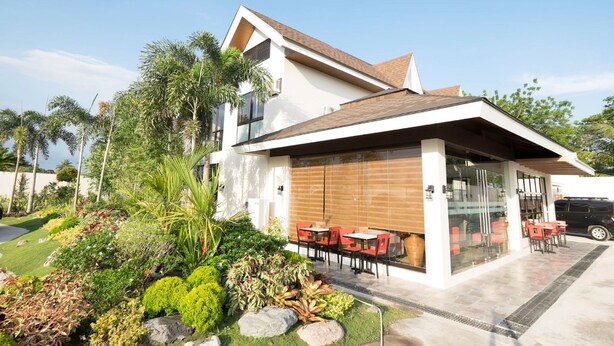Una casa moderna con un patio que incluye mobiliario exterior.