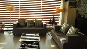 Una sala de estar con sofá, mesa de centro y lámpara.