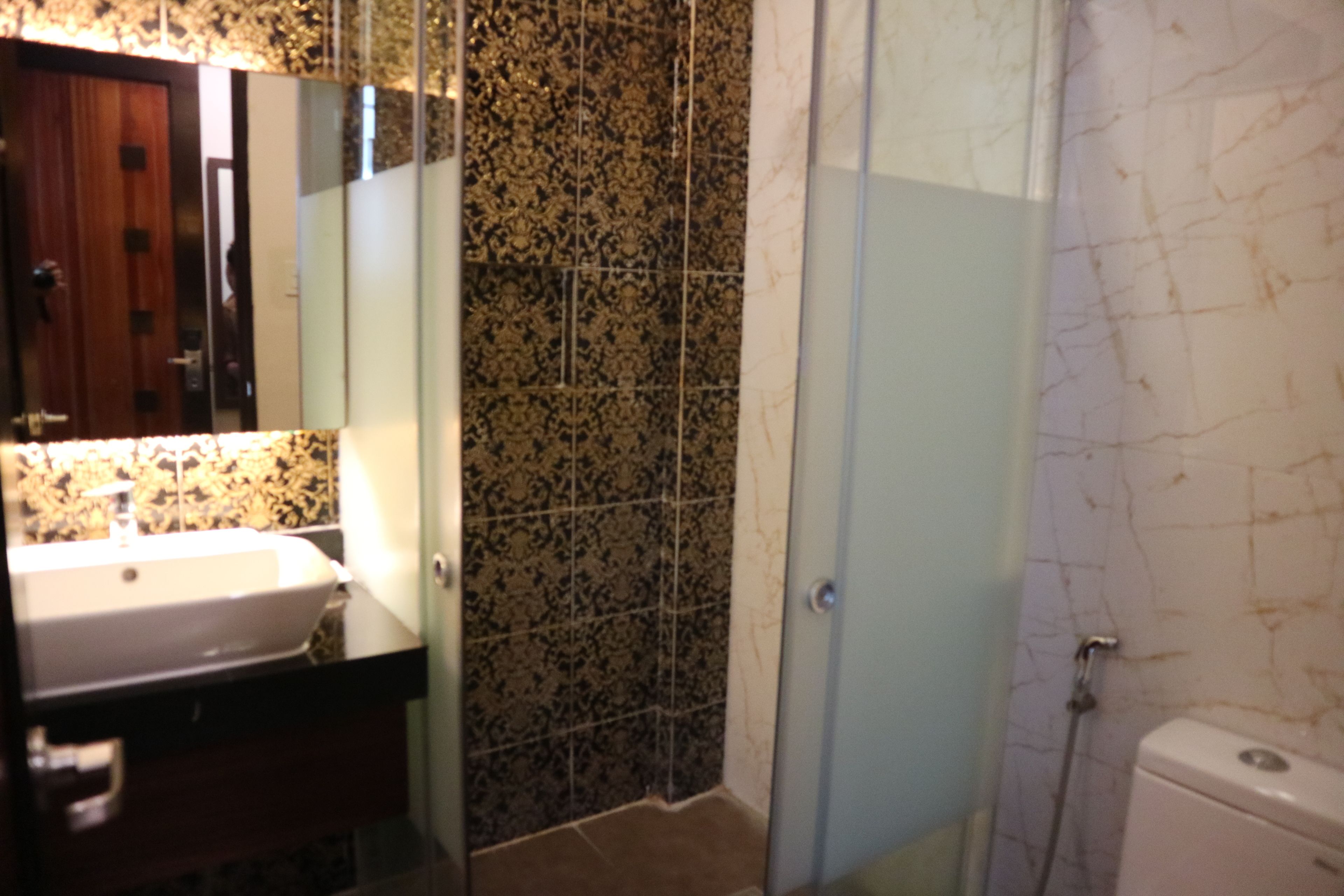 Ein Badezimmer mit Waschbecken, Spiegel, Dusche und Toilette.