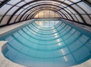 A large indoor swimming pool with a curved glass ceiling. - Villa Cheti (Spigno Monferrato)