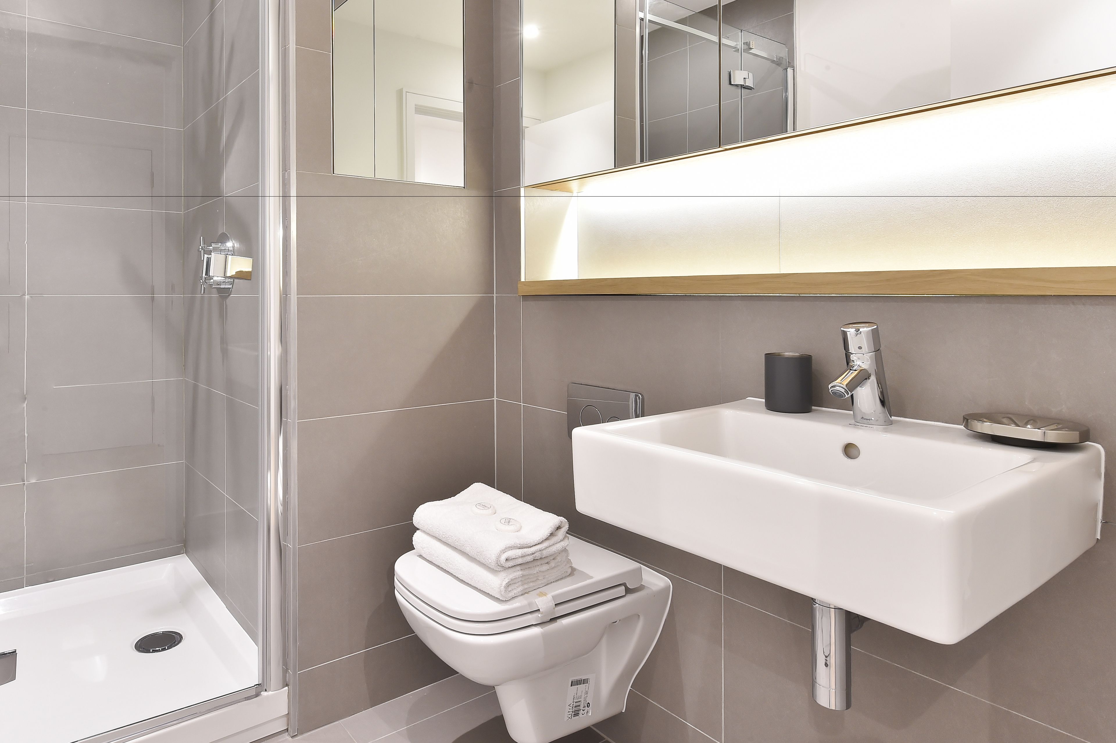 A modern bathroom with a shower, toilet, and sink.