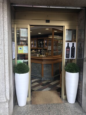 A bar area with a counter, glassware, and a menu board. - Hostal Zahara (Ferrol)