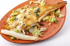 A roasted chicken with vegetables on a plate. - Hostal Zahara (Ferrol)