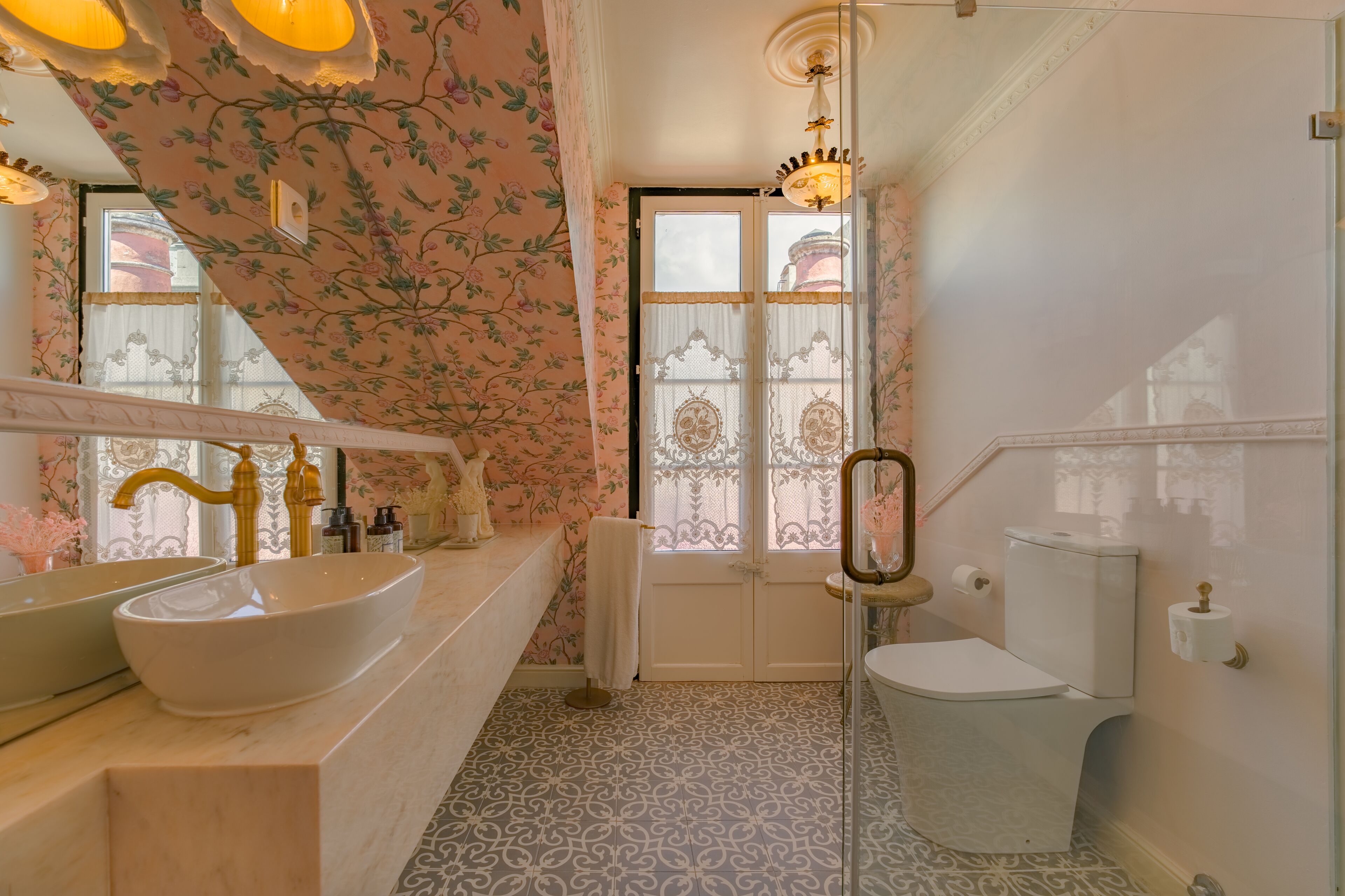 A bathroom with a large white sink, a toilet, and a mirror.
