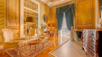 A luxurious room with a large window, ornate furniture, and a classic chandelier.