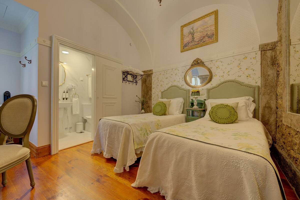 Een slaapkamer met twee bedden, een spiegel en een deur naar een badkamer.