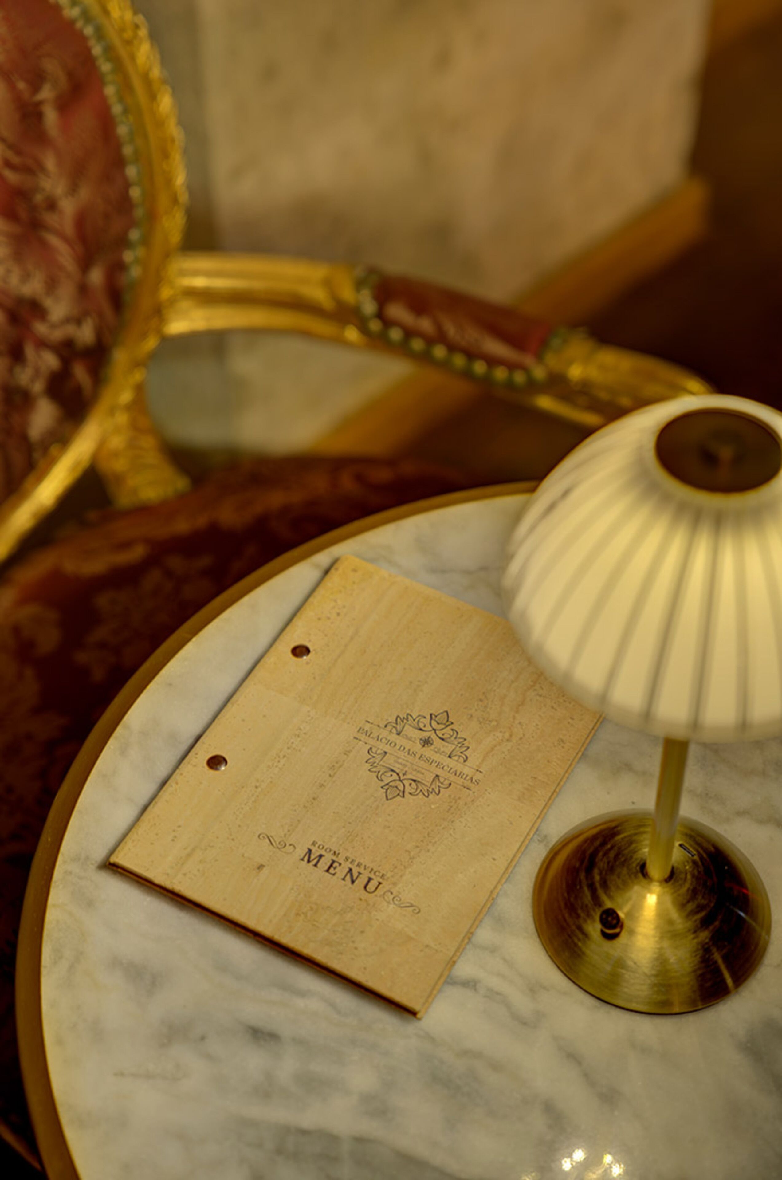 Une table en marbre, avec un menu et une lampe.