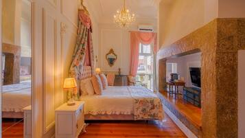 Un dormitorio con cama, mesita de noche, lámpara y espejo.