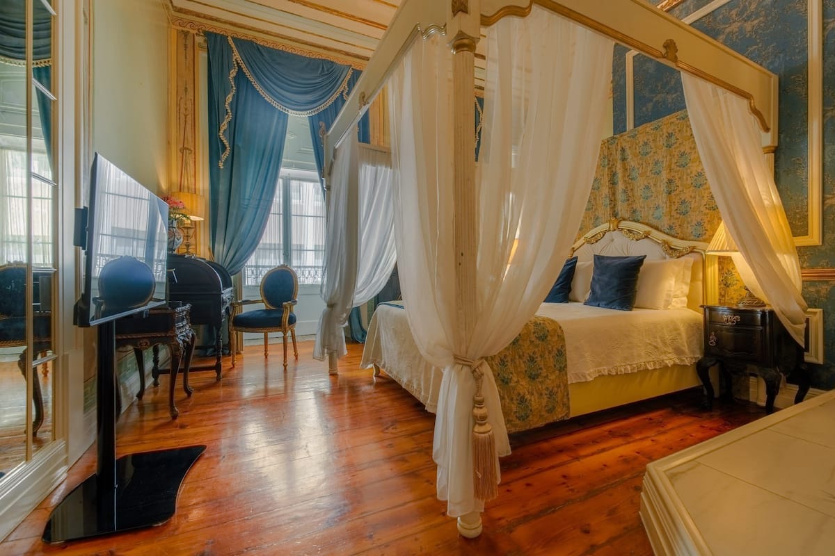 Een hemelbed, een bureau met stoel en een grote spiegel.