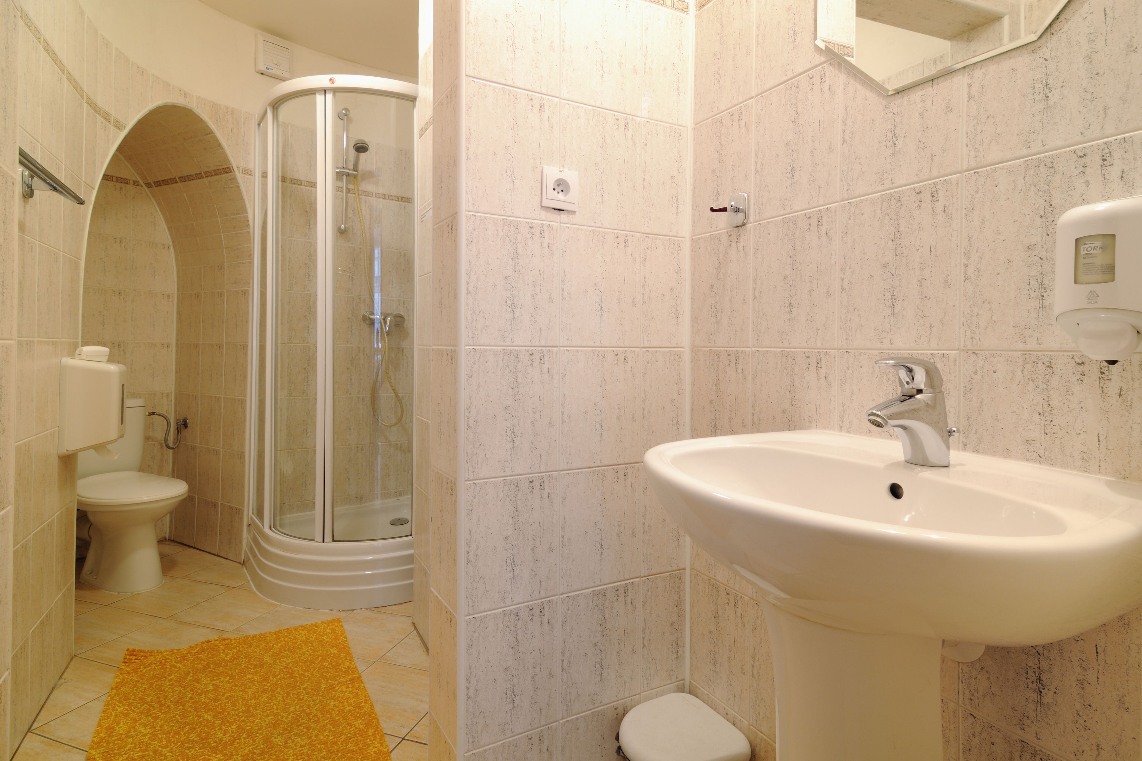 A bathroom with a shower, toilet, and sink.