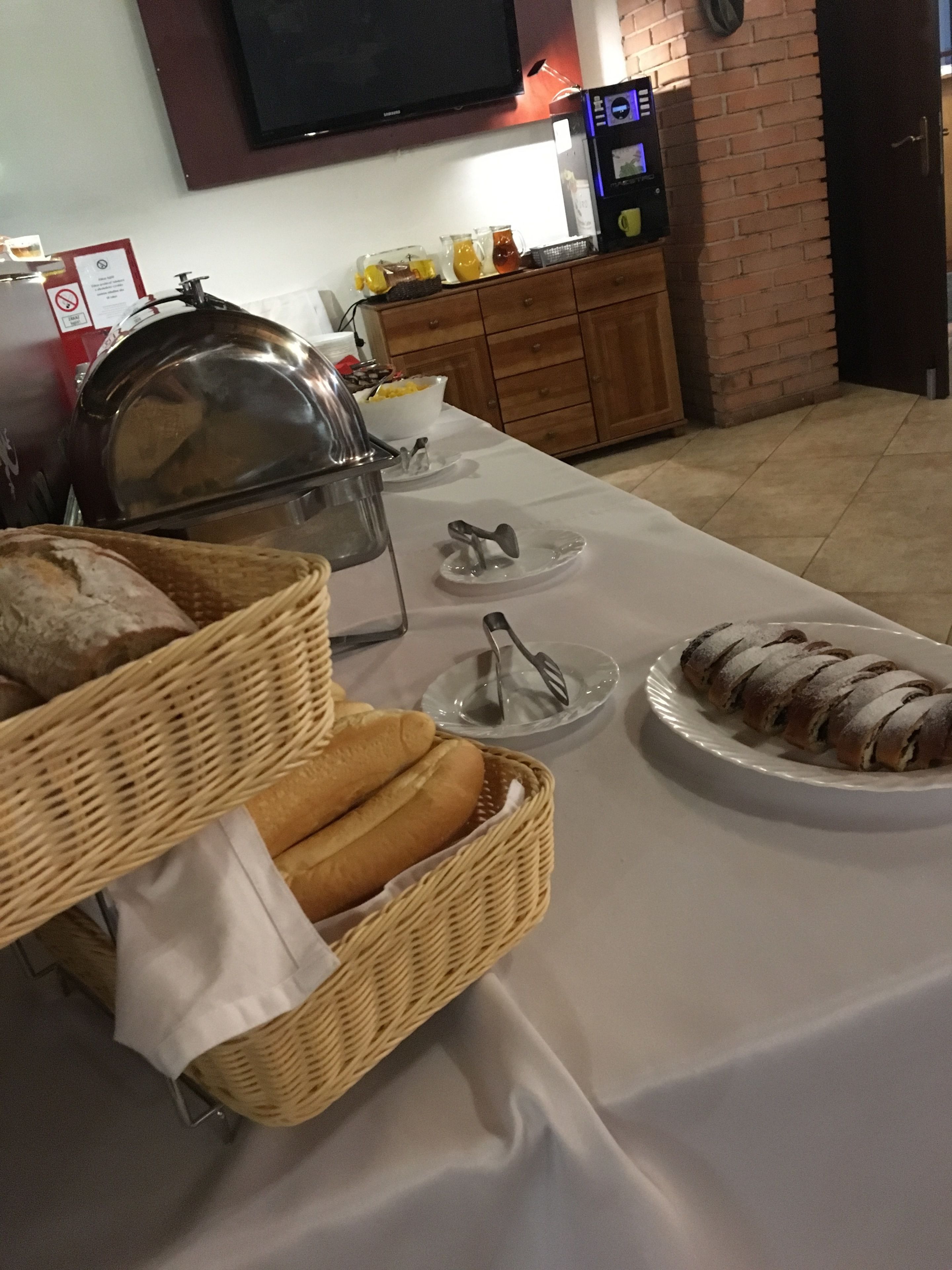 A buffet setup with bread, a cake, and a coffee machine.