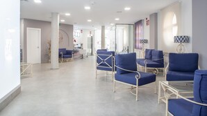 A modern waiting area with blue chairs and a reception desk. - Hotel ITC Artemisa by Soho Boutique (Seville)