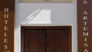 A wooden double door with metal studs, flanked by two vertical signs with text, and a small window above the door. - Hotel ITC Artemisa by Soho Boutique (Seville)