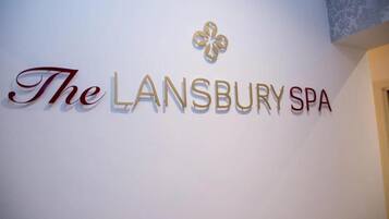 A wall with the text "The Lansbury Spa" and a decorative emblem.
