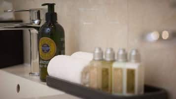 A bathroom with a bottle of Octane body wash, a towel, and a set of toiletries.