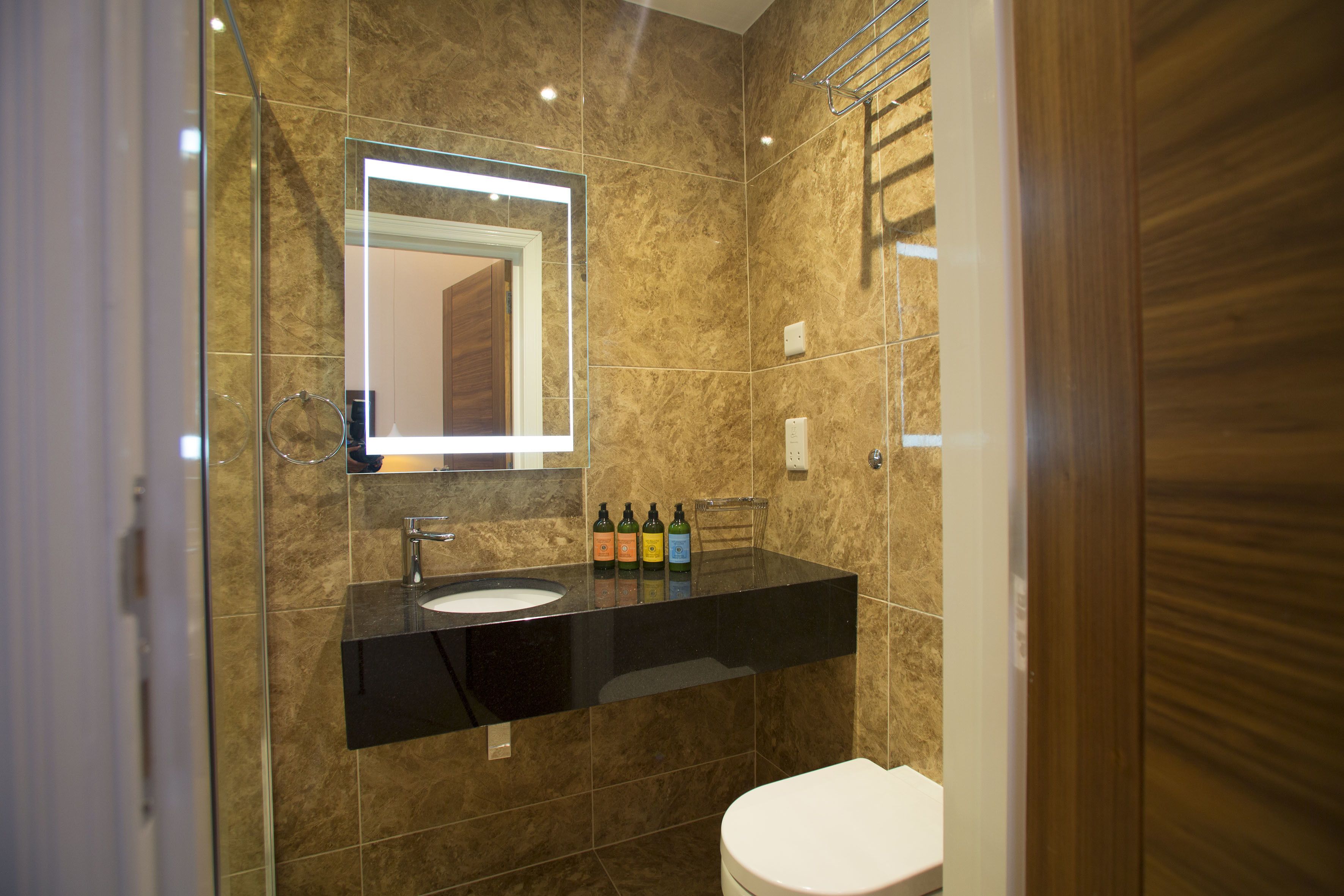A modern bathroom with a black sink, a mirror, and a toilet.