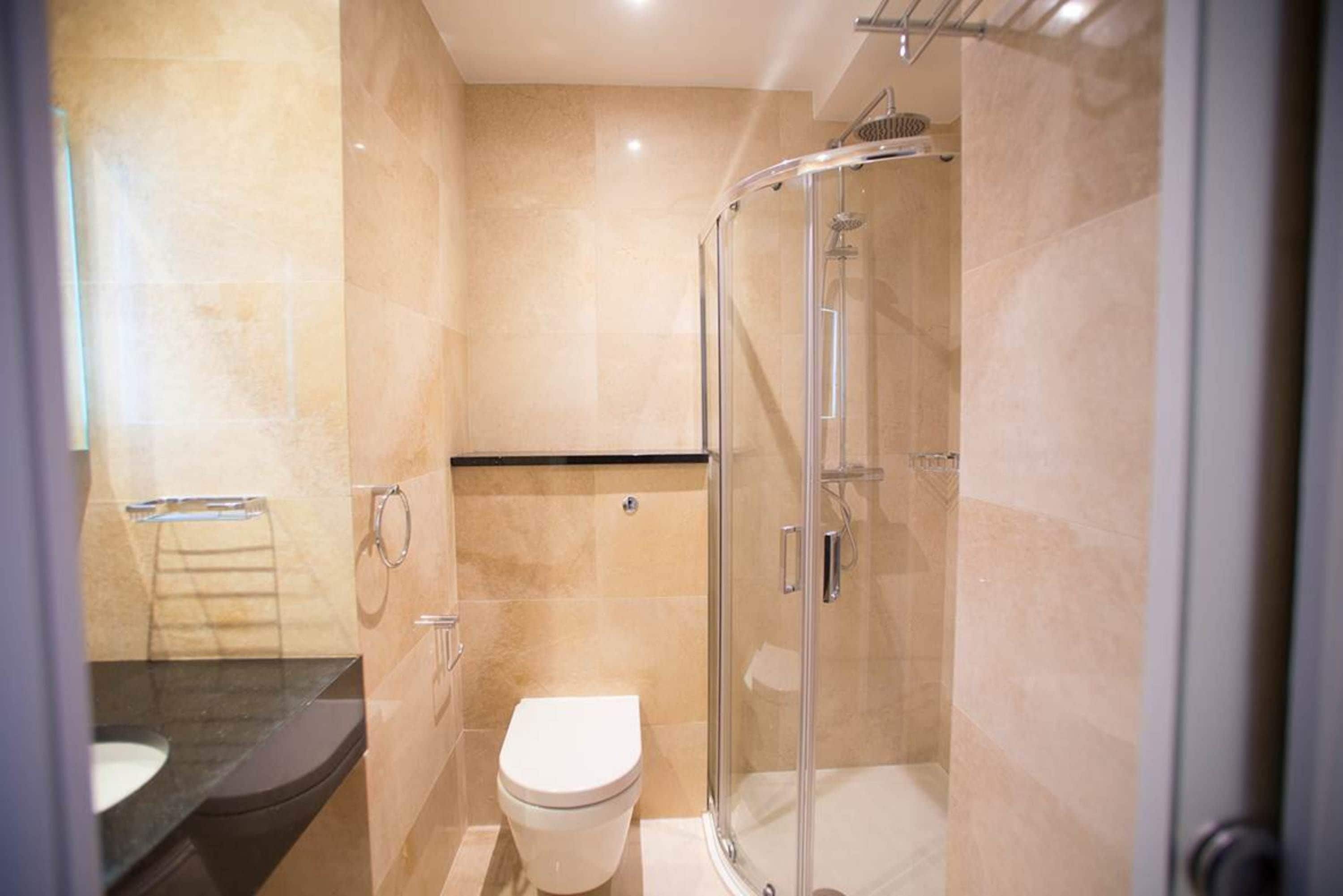 Ein modernes Badezimmer mit einer Duschkabine aus Glas, einer Toilette und einem Waschbecken.