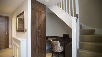 A home office with a desk, chair, and a staircase.