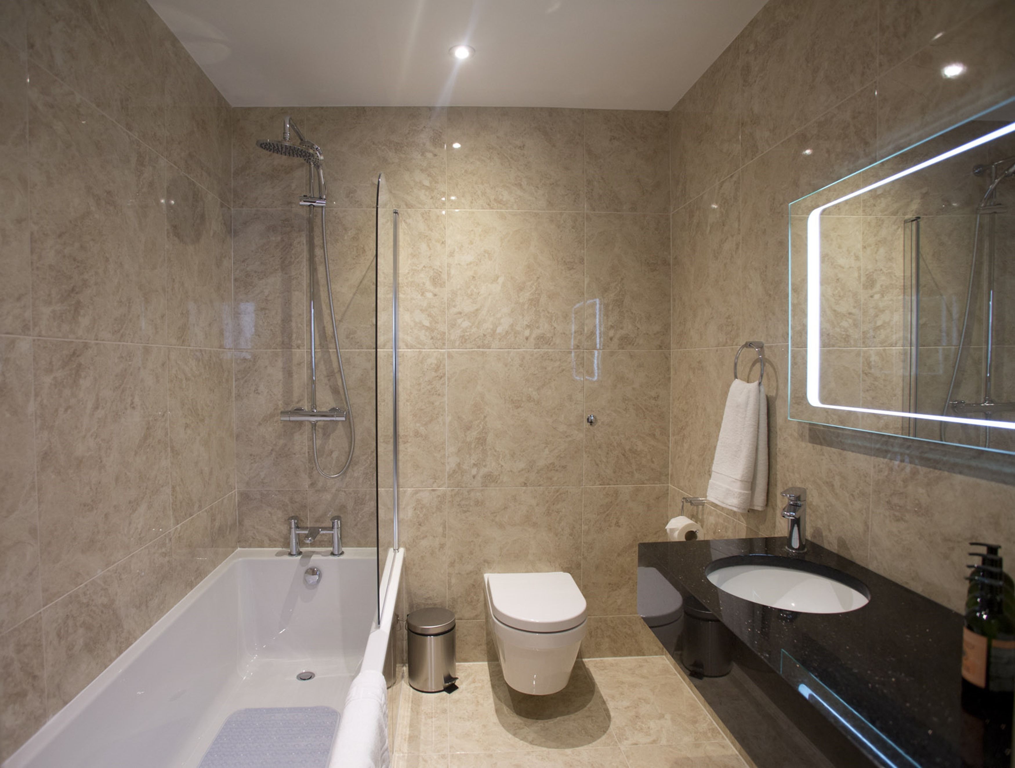 Un baño moderno con bañera, inodoro y lavamanos.
