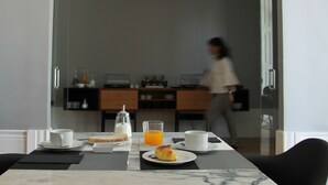 A breakfast table with a cup, a glass of orange juice, a croissant, and a bottle of milk. - Porto Music Guest House (Porto)
