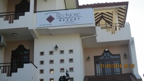 Un bâtiment portant une enseigne « Redstone Resort », doté de balcons, d’un escalier et d’un toit recouvert de tuiles.