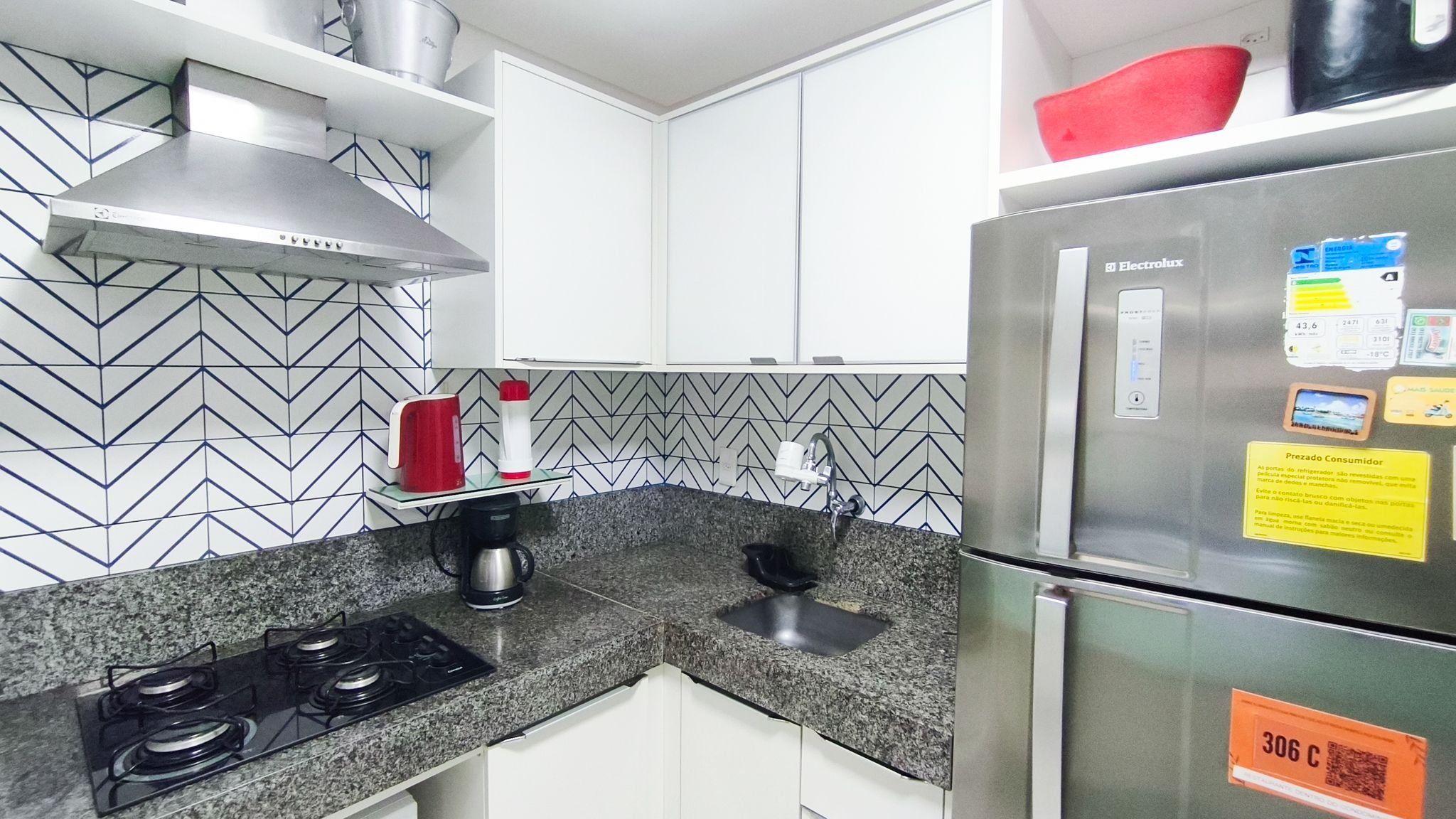 Una cucina con frigorifero in acciaio inossidabile, piano cottura a gas e macchina del caffè.
