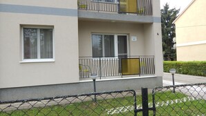 A multi-story residential building with balconies, a fenced yard, and a sign indicating a 5-star rating. - Hajdu Vendeghaz (Hajduszoboszlo)