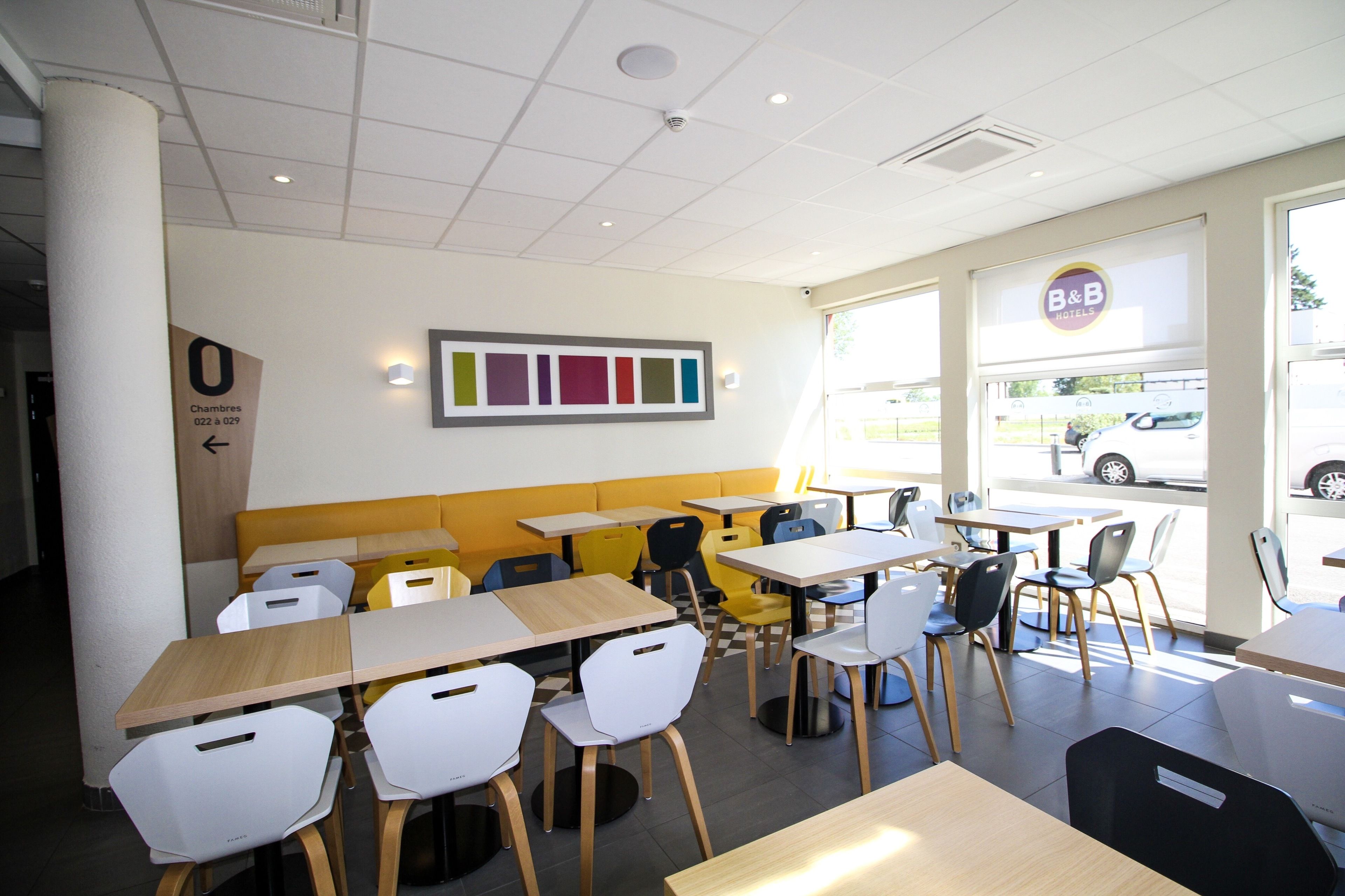 A modern restaurant interior with booths, tables, and chairs.
