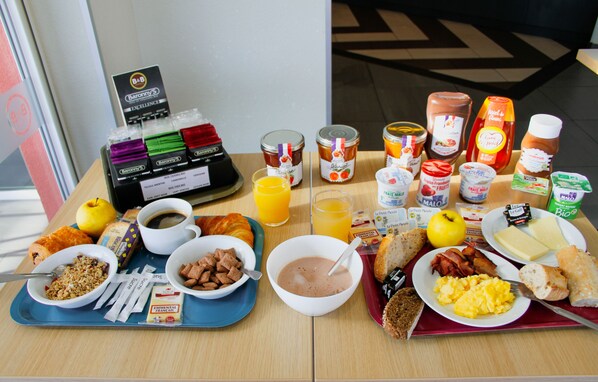 A breakfast tray with various food items, including cereal, eggs, toast, and juice. - B&B HOTEL VALENCE TGV-Romans (Alixan)