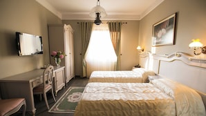 A hotel room with two beds, a desk, a chair, a television, and a painting on the wall. - Hotel Victoria (Tirana)