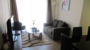 Familieleilighet, 3 soverom, balkong, bassengutsikt | Oppholdsrom | En 50-tommers Flatskjerm-TV med kabel-kanaler samt TV