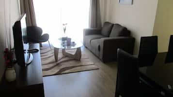 Departamento familiar, 3 habitaciones, balcón, vista a la alberca | Sala de estar | Televisión de pantalla plana de 50 pulgadas con canales por cable