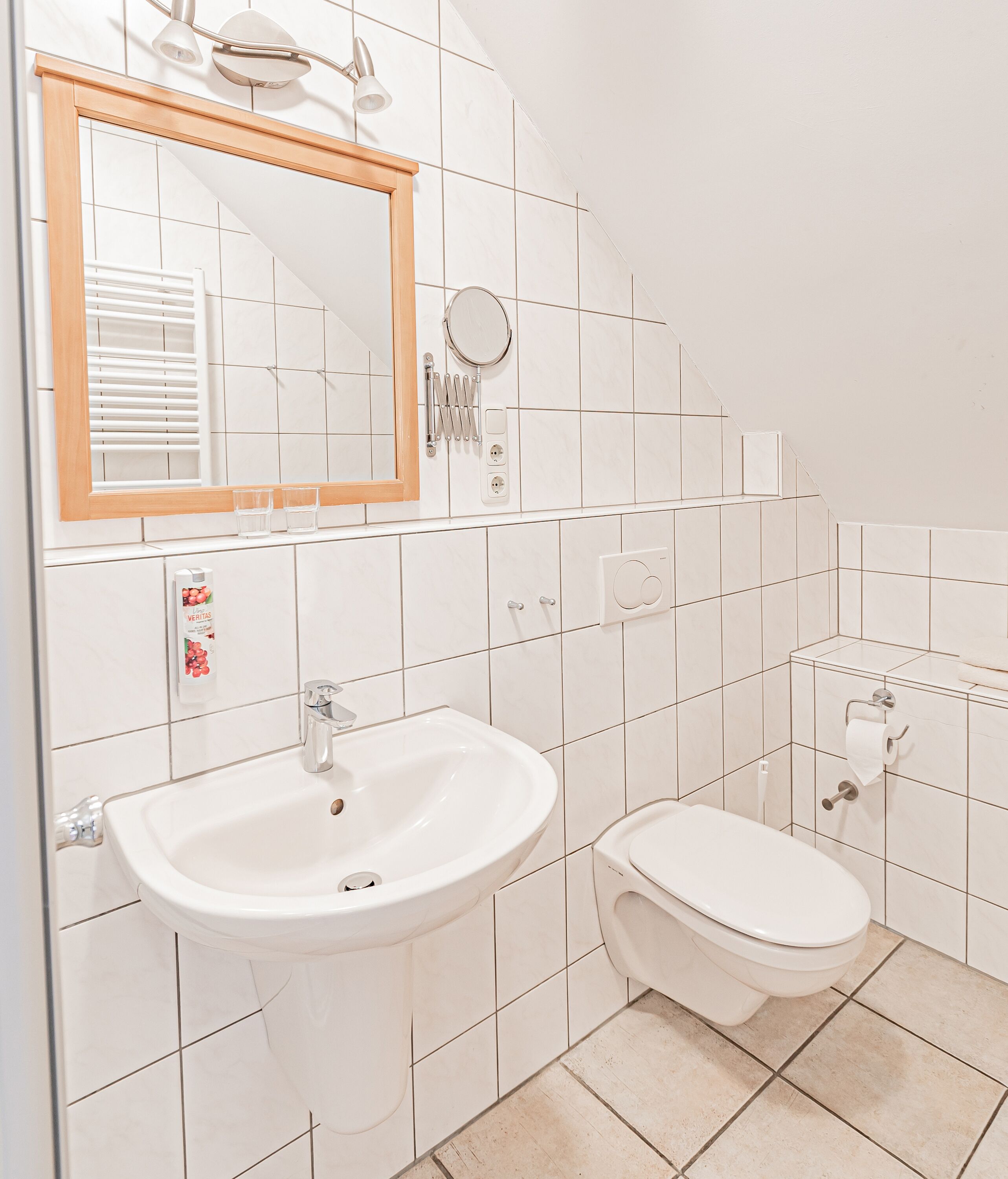 A bathroom with a sink, toilet, and a mirror.